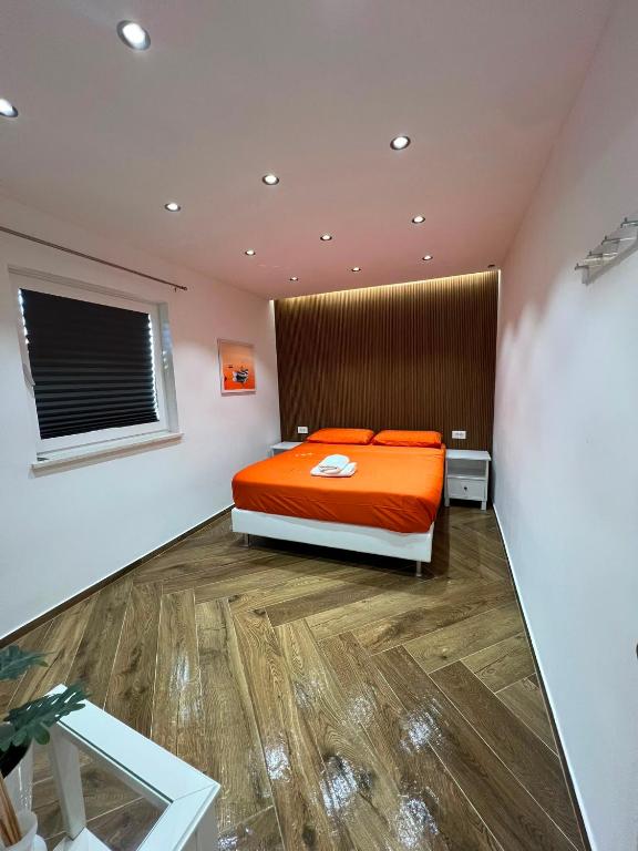 a bedroom with an orange bed and a window at Casa Trussardi in Pirovac