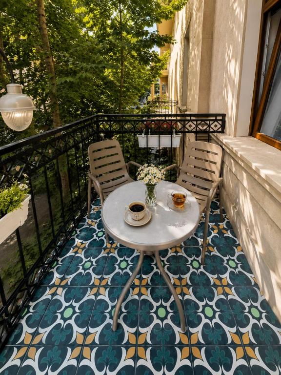 a balcony with a table and chairs on a mosaic floor at Amara Boutique in Baku