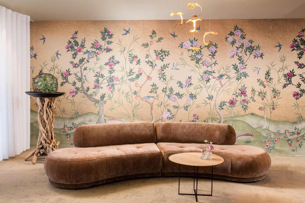 a couch in a living room with a floral wallpaper at Best Western Hotel Mainz in Mainz