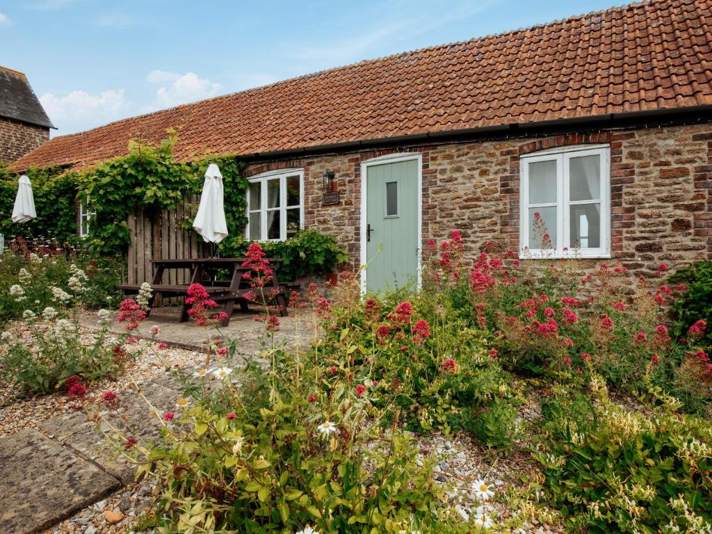a brick cottage with a green door and flowers at Keepers Cottage - Ukc3950 in Puncknowle