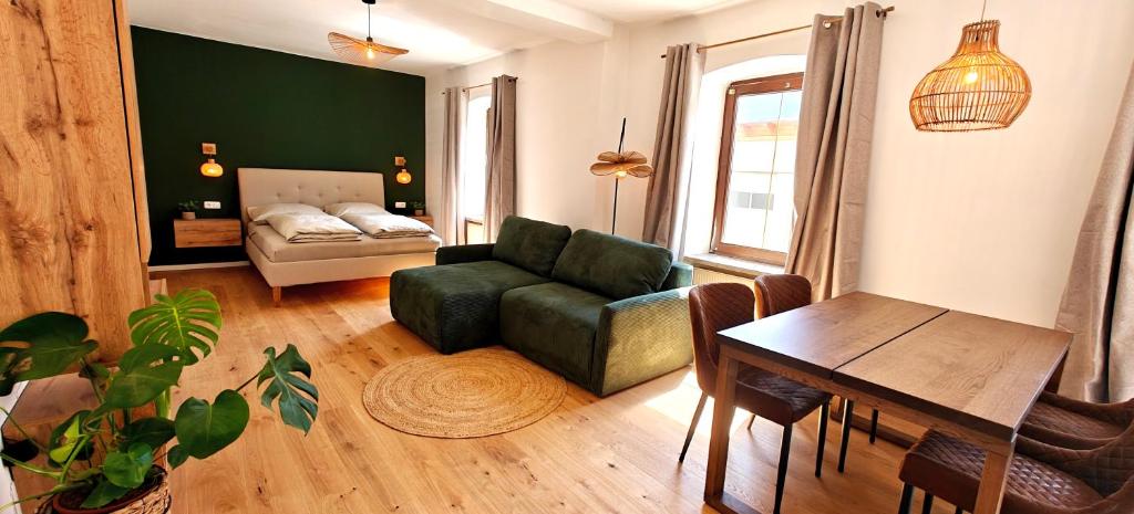 a living room with a green couch and a table at Ferienwohnungen Meier in Ebensee