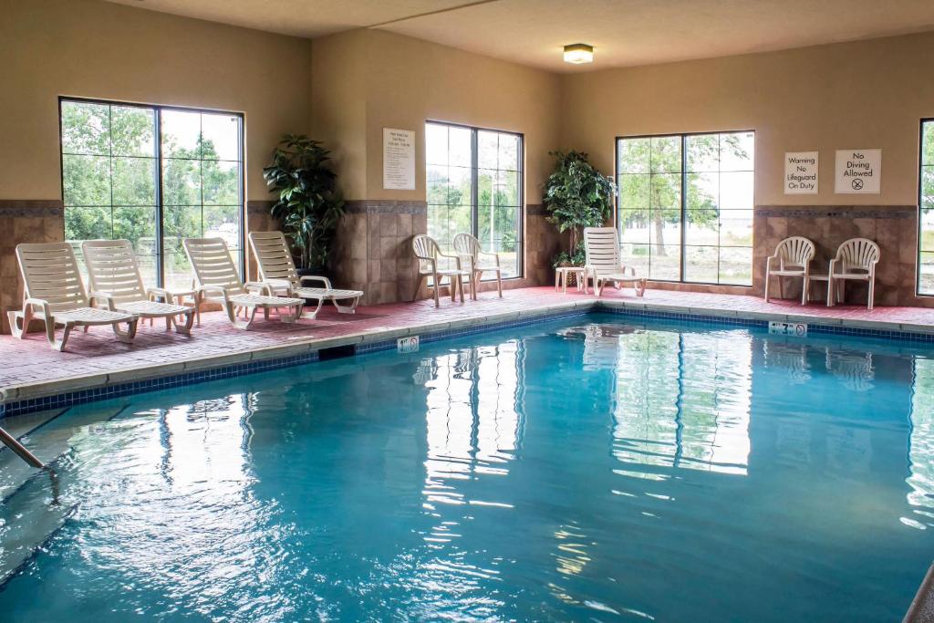 a swimming pool with chairs and tables and windows at Econo Lodge Ankeny - Des Moines in Ankeny