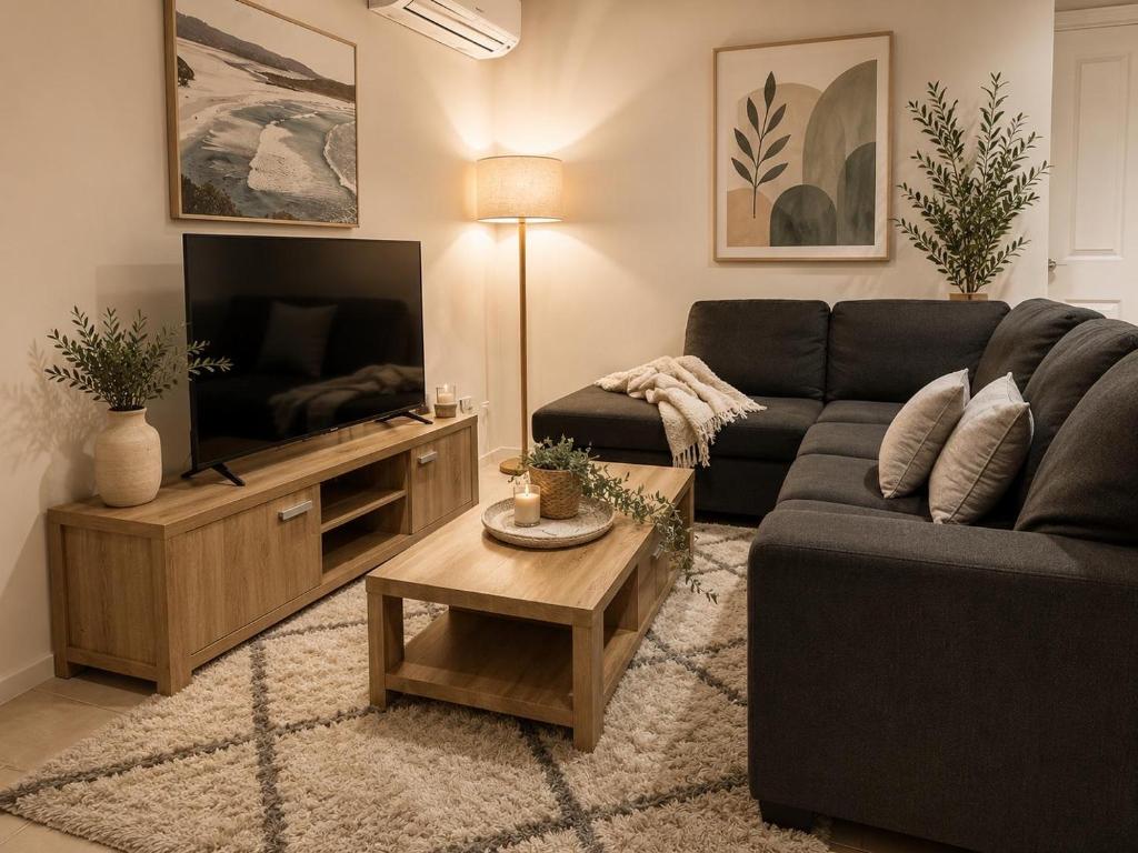 a living room with a couch and a television at Coastal Haven Retreat 3BR Escape in Kinross in Kinross
