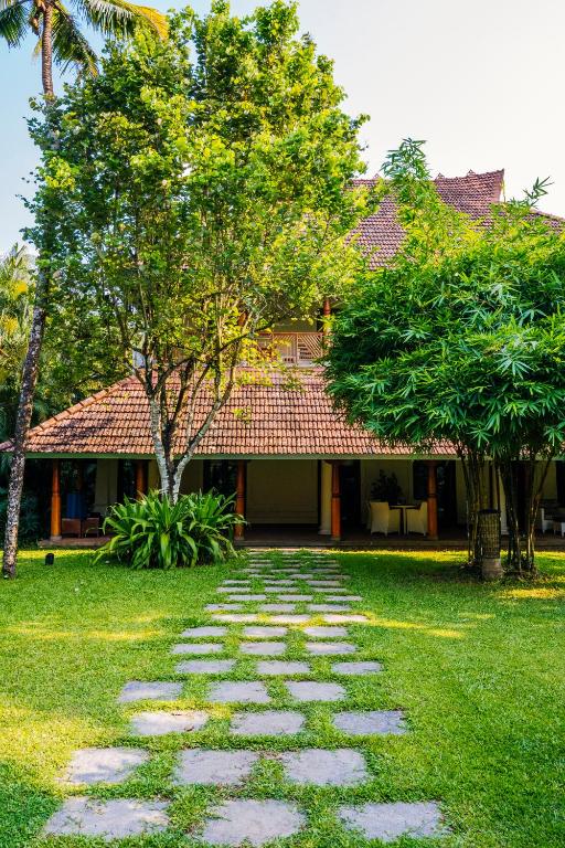 a stone walkway in front of a house at Indian Summer House in Mūvattupula