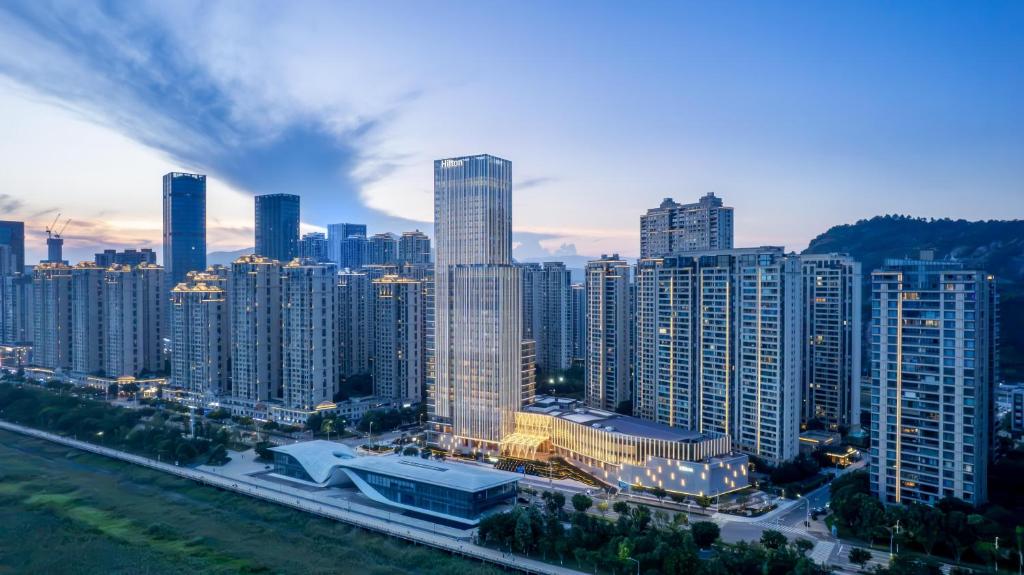 a city skyline with tall buildings in the foreground at Hilton Wenzhou in Wenzhou