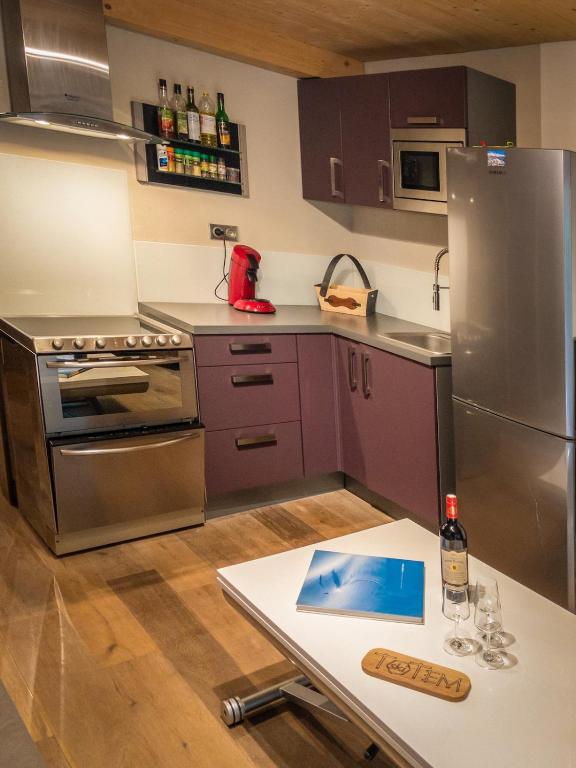 a kitchen with stainless steel appliances and a table at Ski Chalet located Meribell in Les Allues
