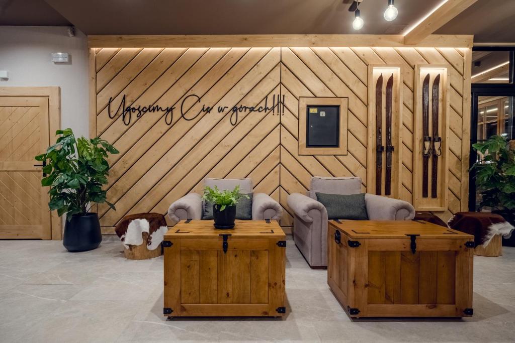 a lobby with chairs and tables and a sign on the wall at Siedlisko Babia Góra in Zawoja