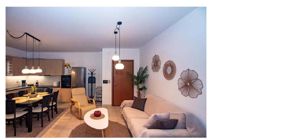 ein Wohnzimmer und eine Küche mit Sofa und Tisch in der Unterkunft Jack Villa's in Chavgas