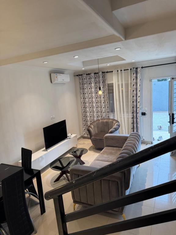 a living room with a couch and a tv and chairs at Duplex nr 3 à Bandal in Kinshasa