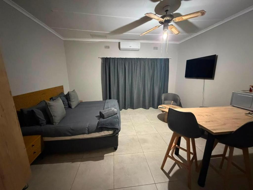 a bedroom with a bed and a dining room table at Green Haven 2 in Tzaneen