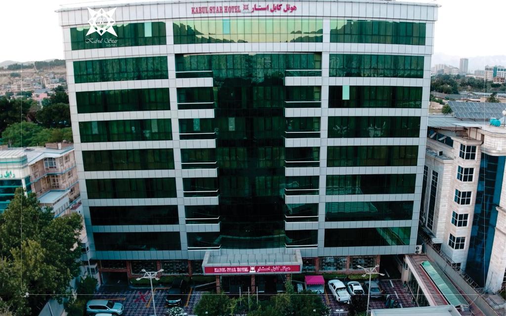 a tall white building with a sign on it at Kabul Star Hotel & Restaurant in Shīrpūr