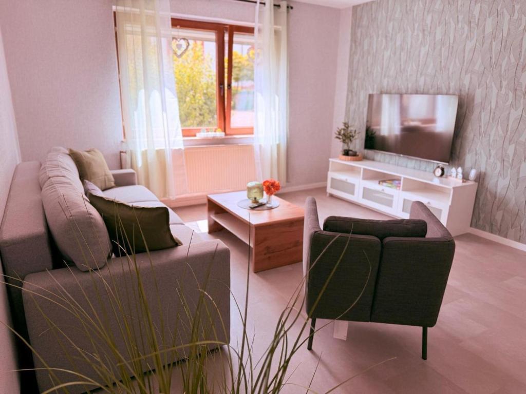 a living room with a couch and a tv at Ferienwohnung Ehrenberg-Feeling in Ehrenberg