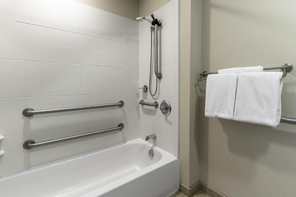 a bathroom with a tub and a shower with towels at Hyatt House Richmond - Short Pump in Short Pump