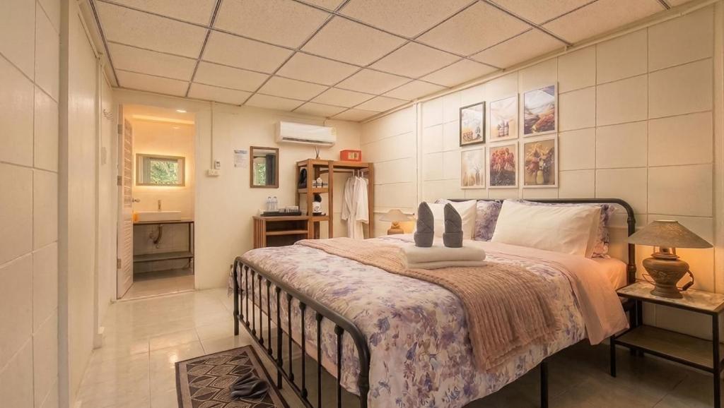 a bedroom with a large bed and a bathroom at Le Panpurie Koh Lanta Resort - Near the Beach in Ko Lanta