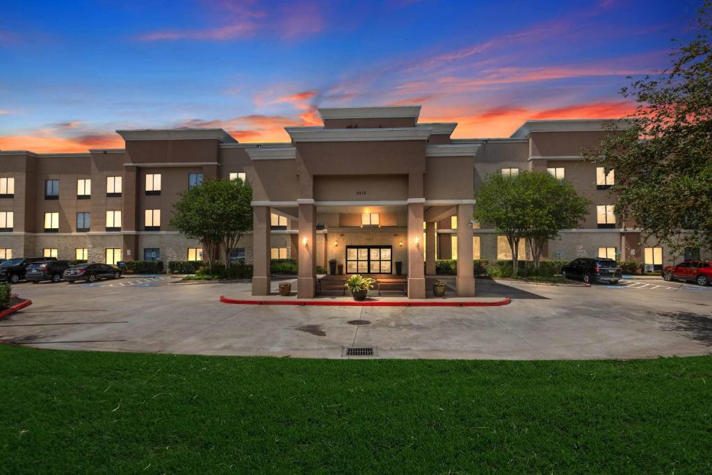 a large building with a parking lot in front of it at Hampton Inn & Suites Houston Rosenberg in Rosenberg