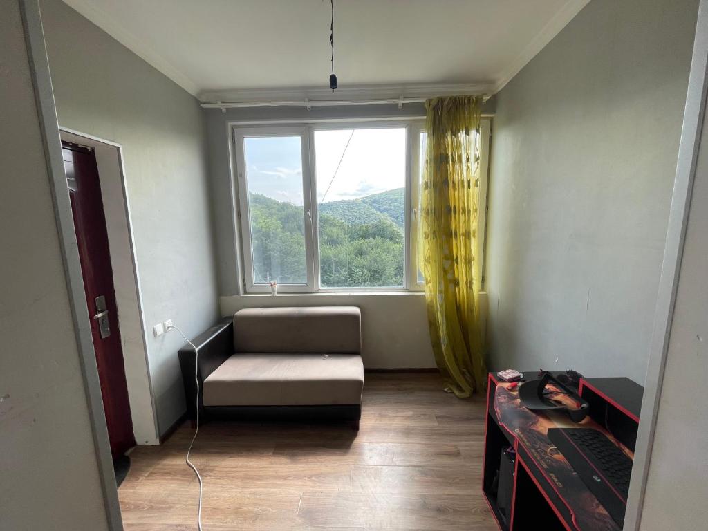a living room with a couch and a window at Mukha in Tbilisi City