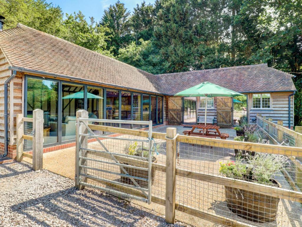 a building with a fence in front of a building at Glebe Stables in Steyning