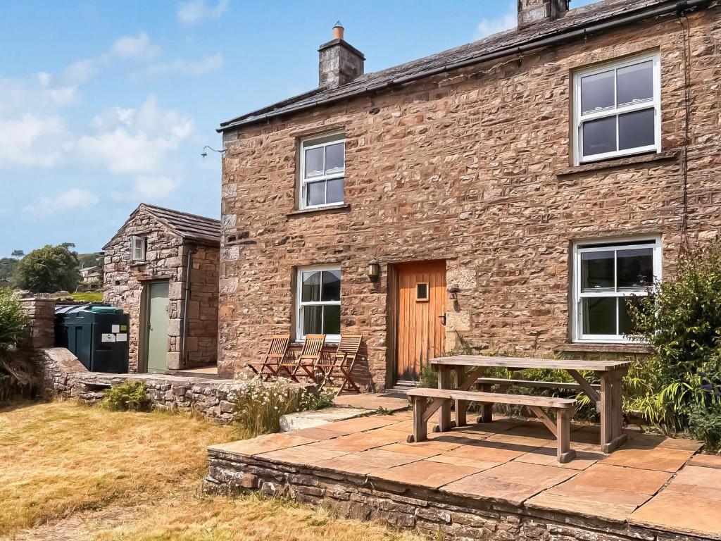 a stone house with a picnic table in front of it at Windy Ridge Low Row in Feetham