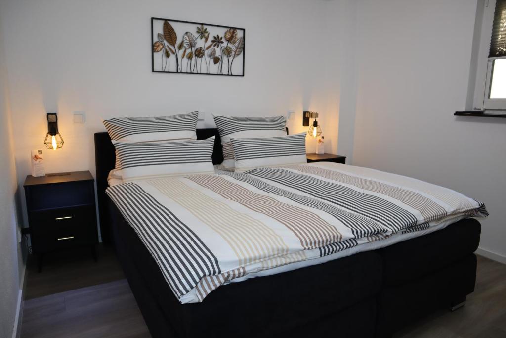 a bedroom with a bed with striped sheets and pillows at Ferienwohnung Frankenruhe in Strullendorf