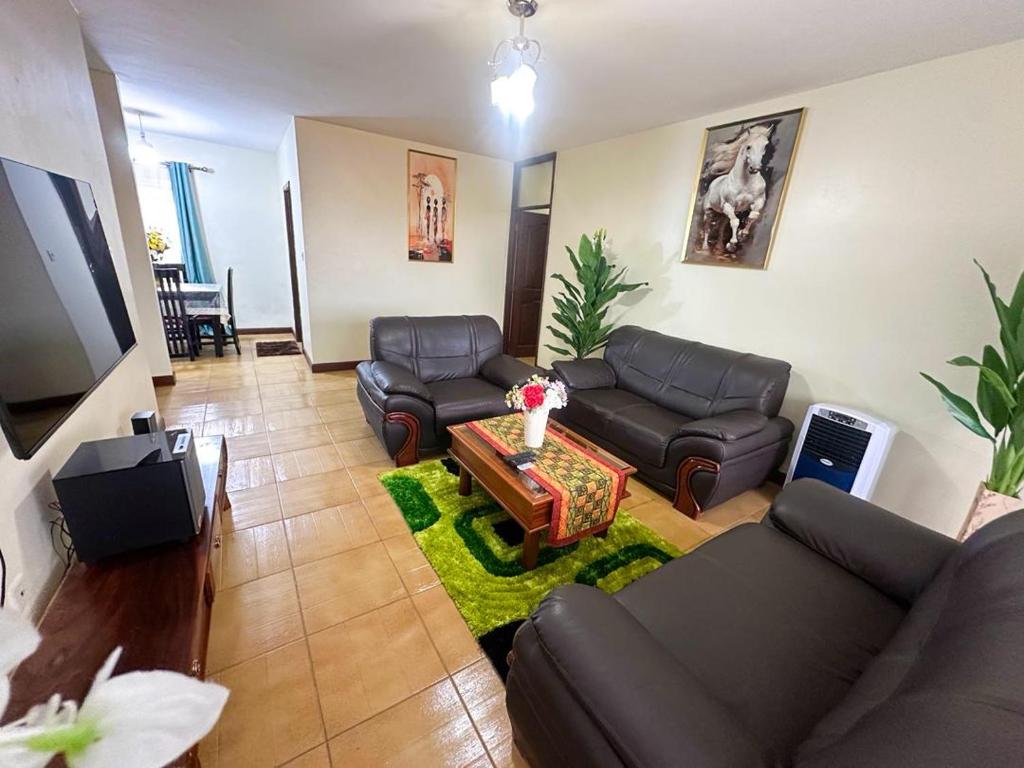 a living room with a couch and a table at MakerereViewAirbnb in Kampala