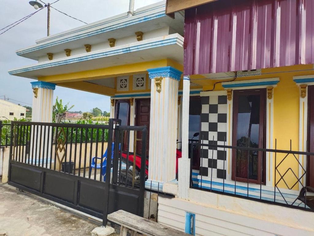 a small house with a porch and a fence at Bahruksi HomeStay in Huta Baju