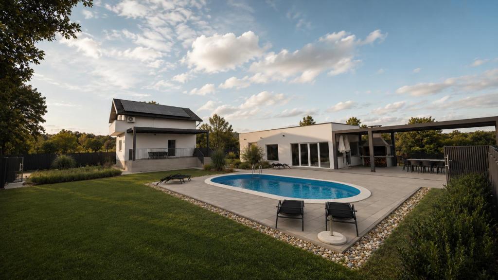 a backyard with a swimming pool and a house at Casa Cordis in Korduševci