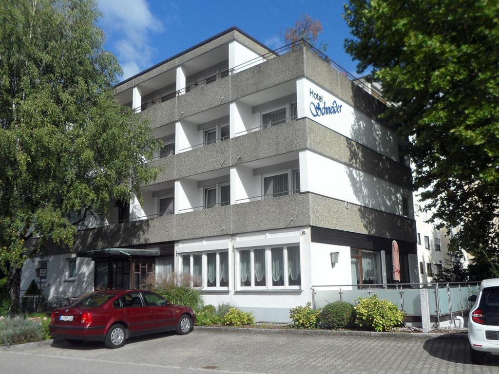 a red car parked in front of a building at Hotel Schneider in Bad Säckingen