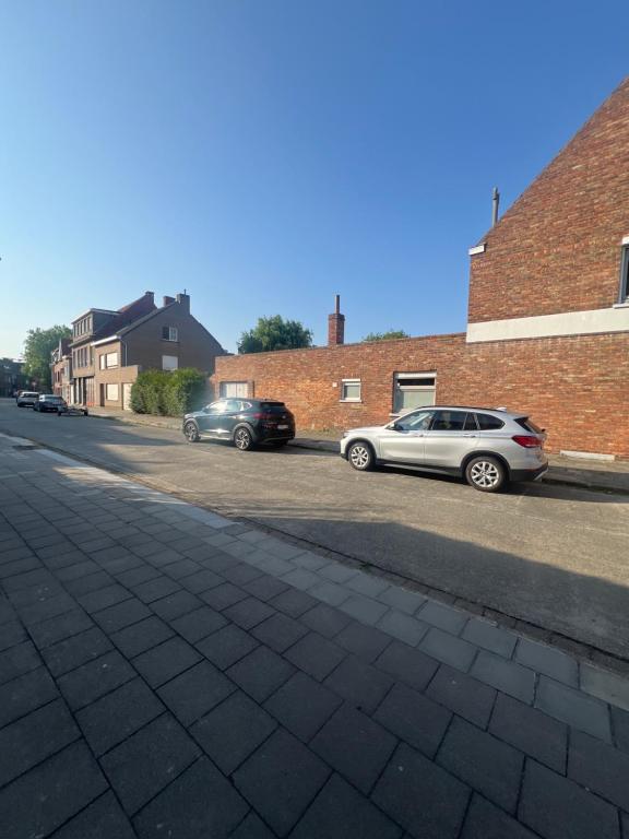 two cars parked on the side of a street at Modern private Rooms with attached Bathroom & Free Parking in Bruges