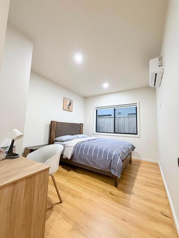 a bedroom with a bed and a desk and a window at Serenity Suite with Private Bathroom in Wyndham Vale