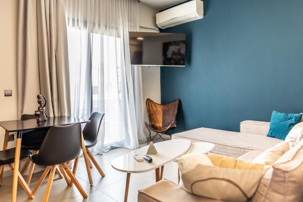 a living room with a couch and a table and chairs at Baja Suites in Kalamata