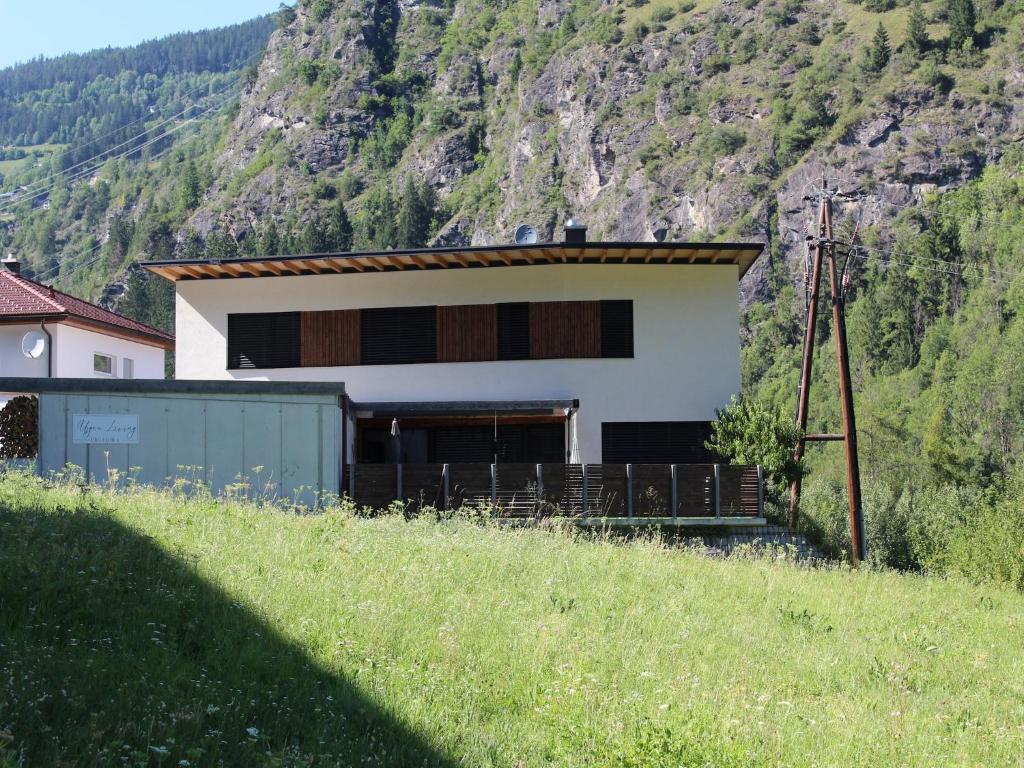 a house on a hill in front of a mountain at Modern apartment in the Tyrolean mountains in Fliess