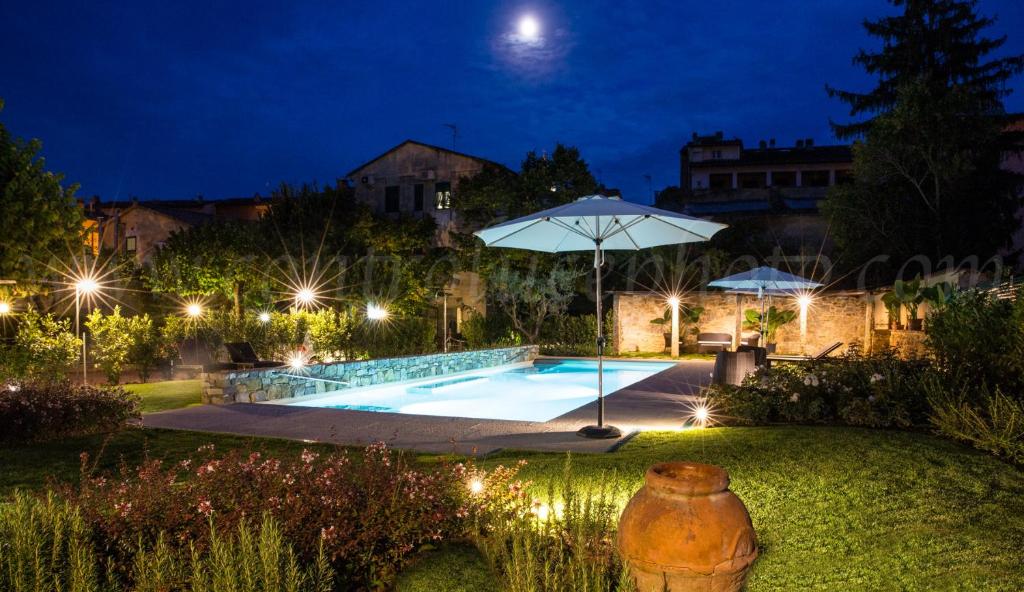 a swimming pool at night with an umbrella at Albergo Stella in Casciana Terme