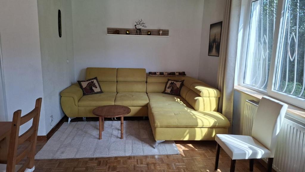 a living room with a yellow couch and a table at Apartment Gms in Schottwien