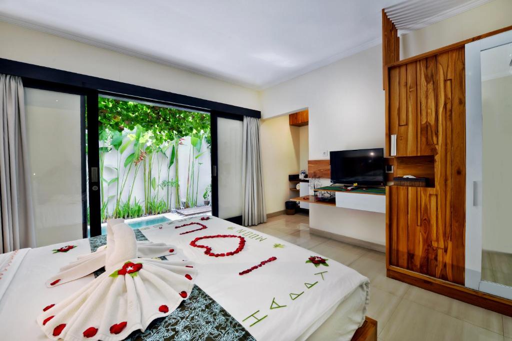 a bedroom with a bed with an umbrella on it at Bali Corail Villas in Kerobokan