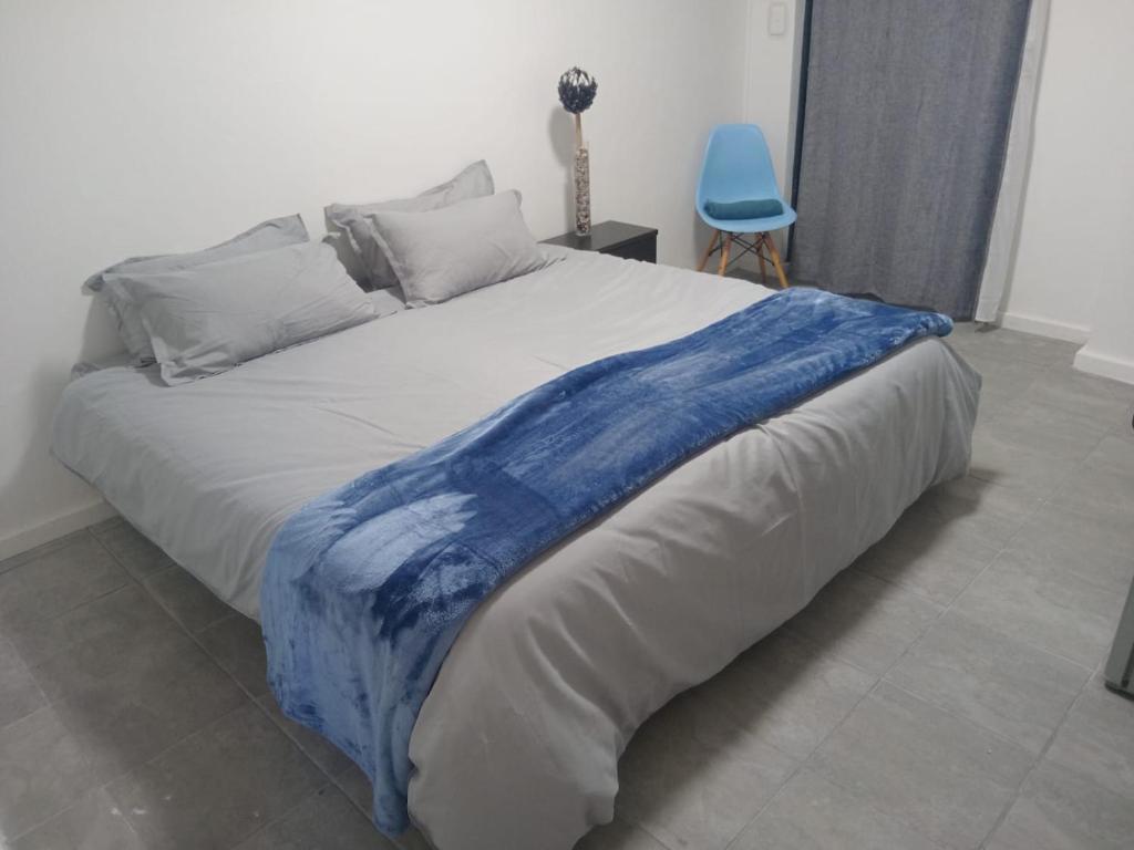 a bed with a blue blanket on top of it at Astros Lodge in Cape Town