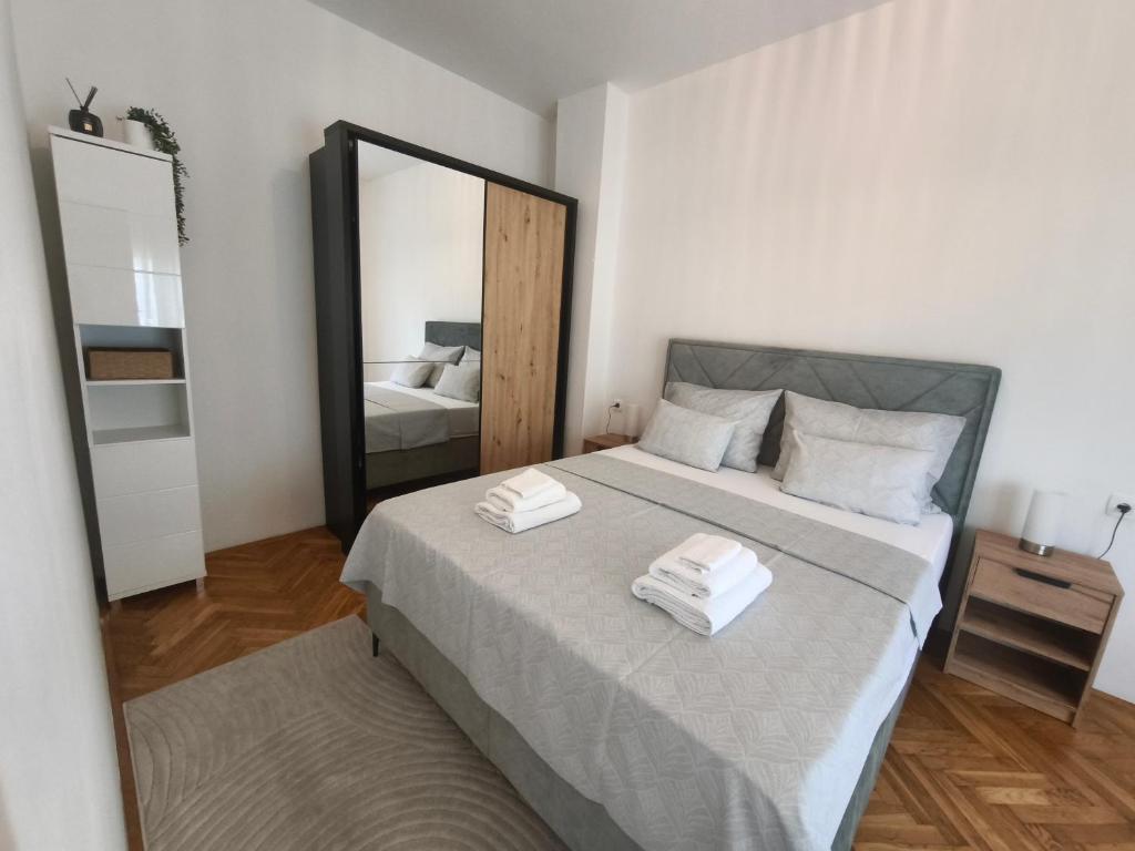 a bedroom with a large mirror and a bed at Apartman-Zara m in Zadar