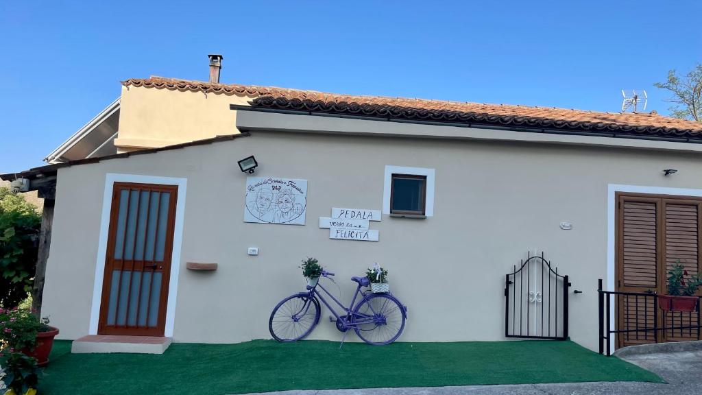 a bike parked on the side of a white house at La casa di Carmela e Francesco b&b in Massa