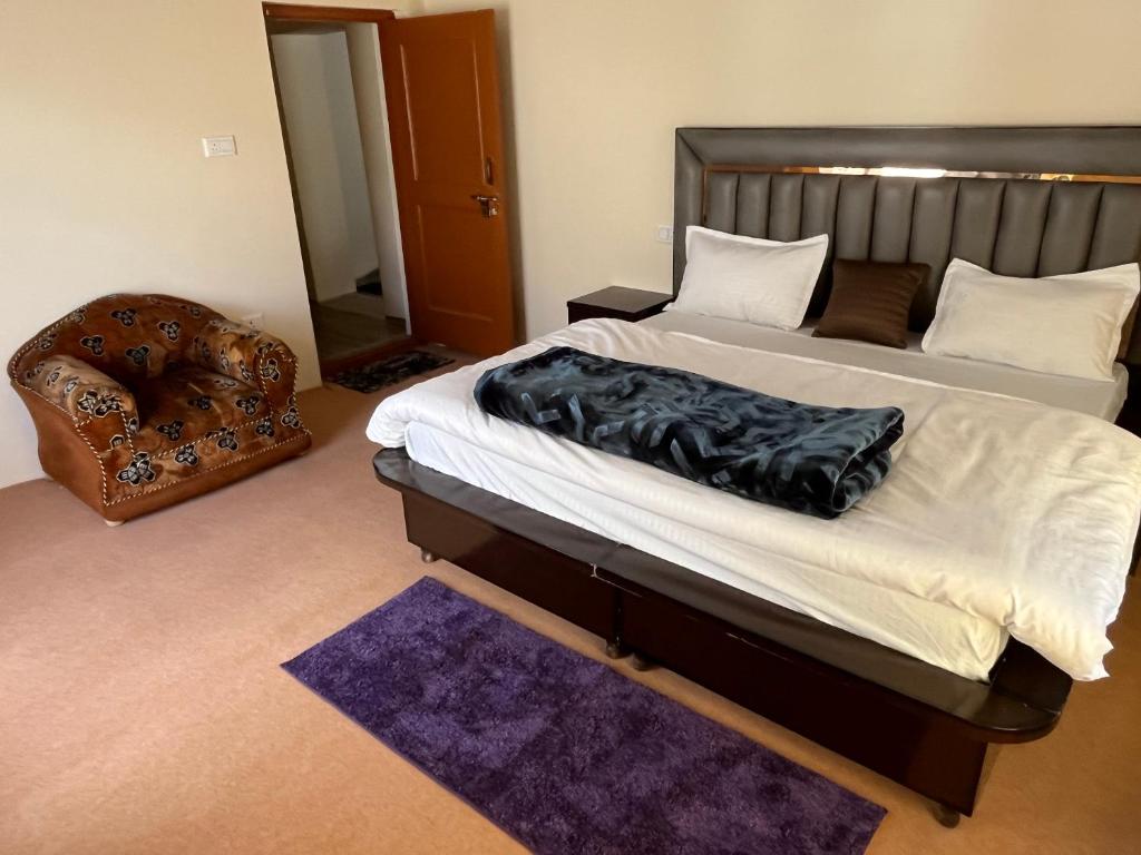 a bedroom with a large bed and a chair at The Norbu Retreat Hull in Kaza