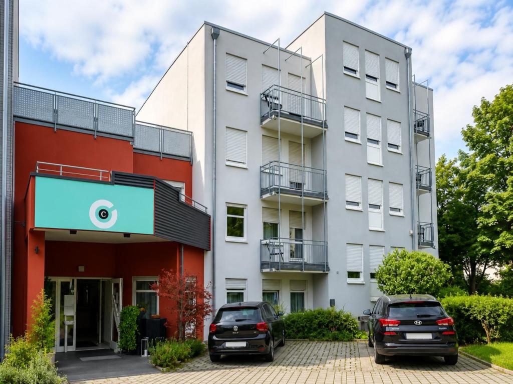 two cars parked in front of a building at Stuttgart Großbettlingen Hotel by Belvilla in Großbettlingen
