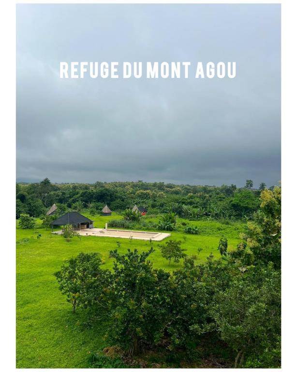 a sign that reads refuge dun mount aco in a field at REFUGE du MONT AGOU in Liatonou