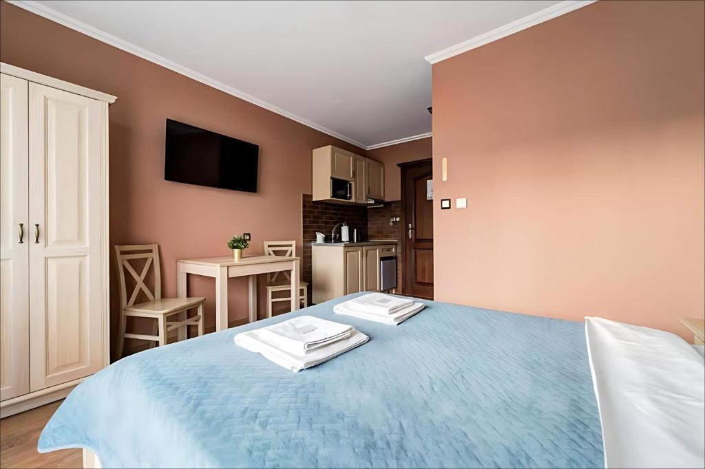 a bedroom with a blue bed with two towels on it at Willa Sichelscy - apartamenty i pokoje z aneksami kuchennymi - rabat 20 procent na Termy Szaflary oraz Gorący Potok oraz 15 procent rabatu na Bramę Gorce in Biały Dunajec