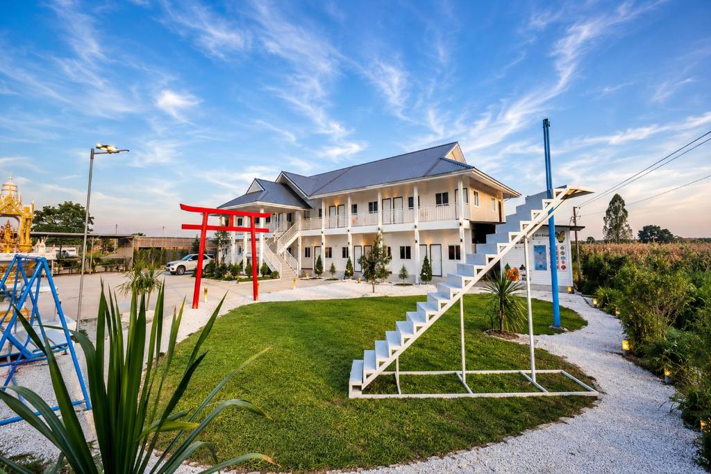 a building with a staircase in front of a playground at White House Hotel Kamphaeng Phet in Ban Tha Dua