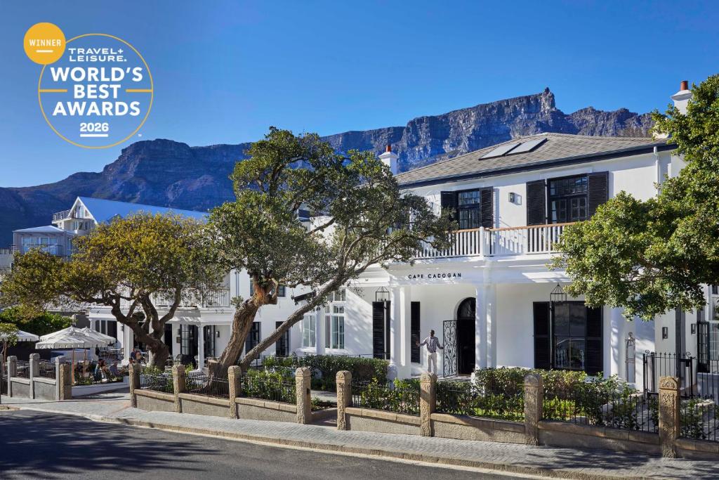 a white house with mountains in the background at Cape Cadogan Boutique Hotel in Cape Town