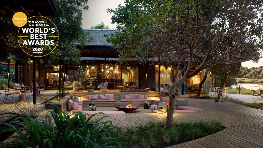 a restaurant with pink couches in a courtyard at Lion Sands River Lodge in Sabi Sand Game Reserve