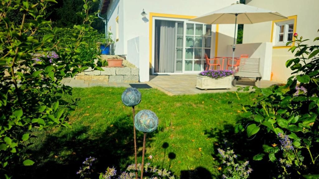 a yard with two blue glass spheres in the grass at Häuschen blaues Pferd in Wallerfing