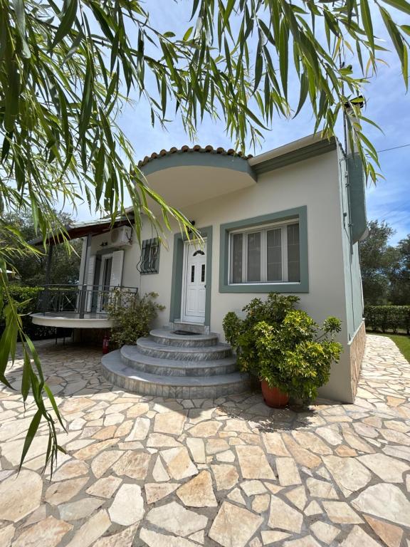 a house with a stone patio in front of it at VILLA ERMIONI in Melíkia