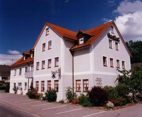 ein großes weißes Gebäude mit rotem Dach in der Unterkunft Hotel Gasthof am Schloß in Pilsach