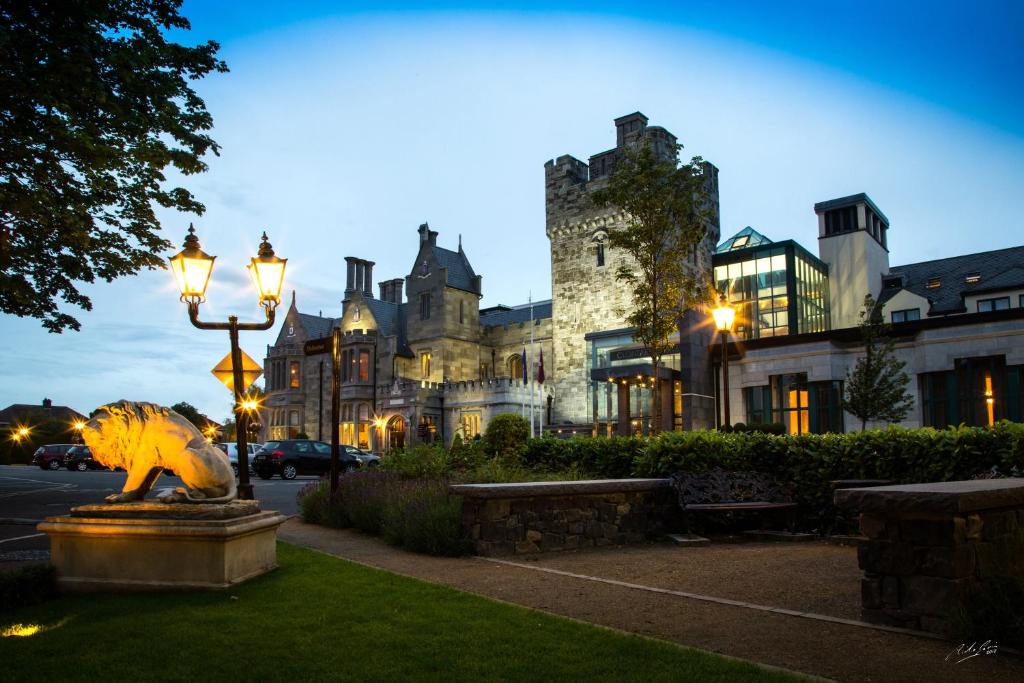 a large building with a lion statue in front of it at Clontarf Castle Hotel in Dublin