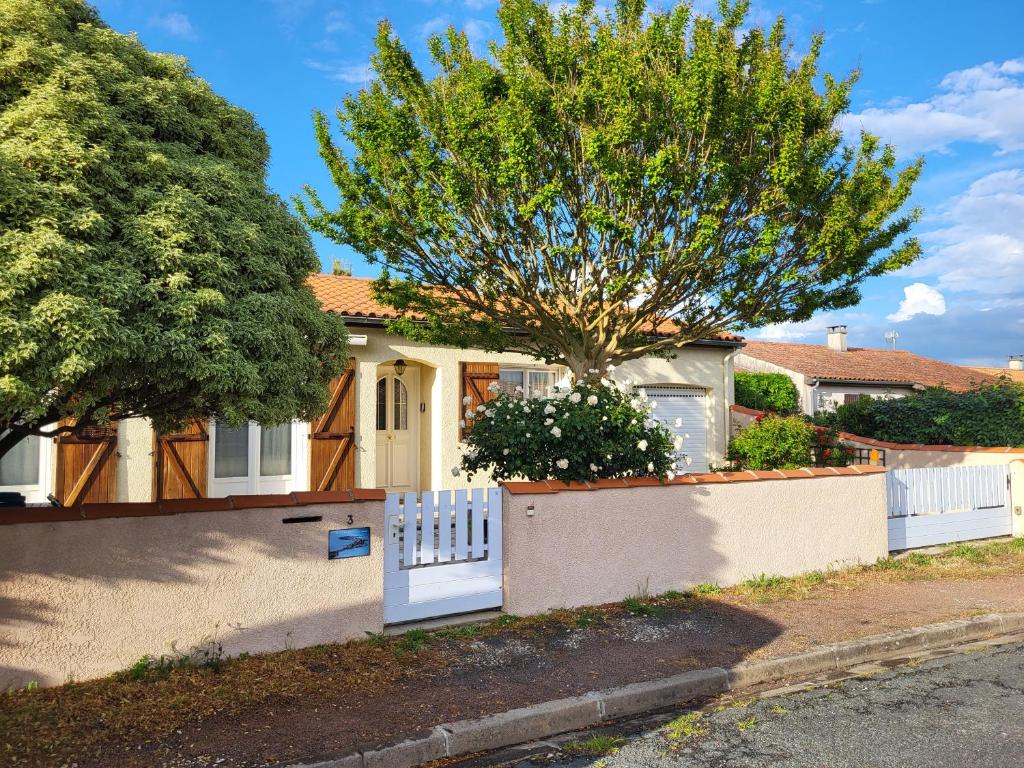 a house with a white fence and a tree at Maison familiale à Fouras-Plage & centre à pied in Fouras