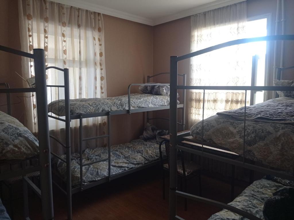 a room with three bunk beds and a window at Esco Hostel in Nardaran